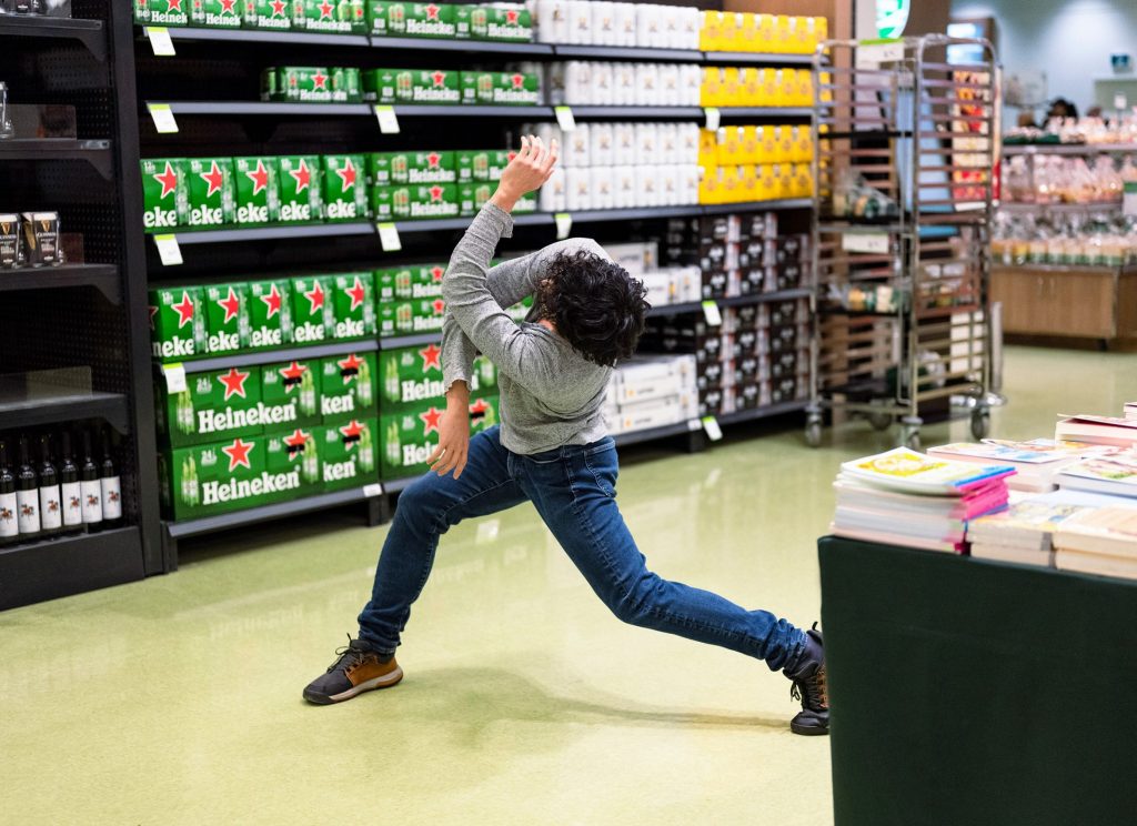 Ballet dancer posing between grocery aisles inside a Toronto supermarket.